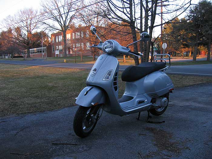 Vespa GTS scooter in a driveway.
