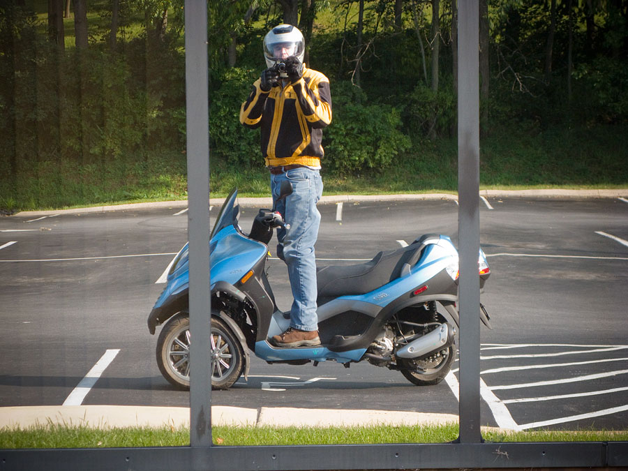 Steve Williams standing on Piaggio MP3 250 scooter