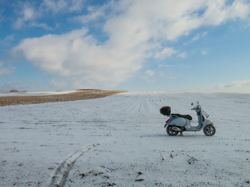 Vespa GTS scooter in snowy farm field