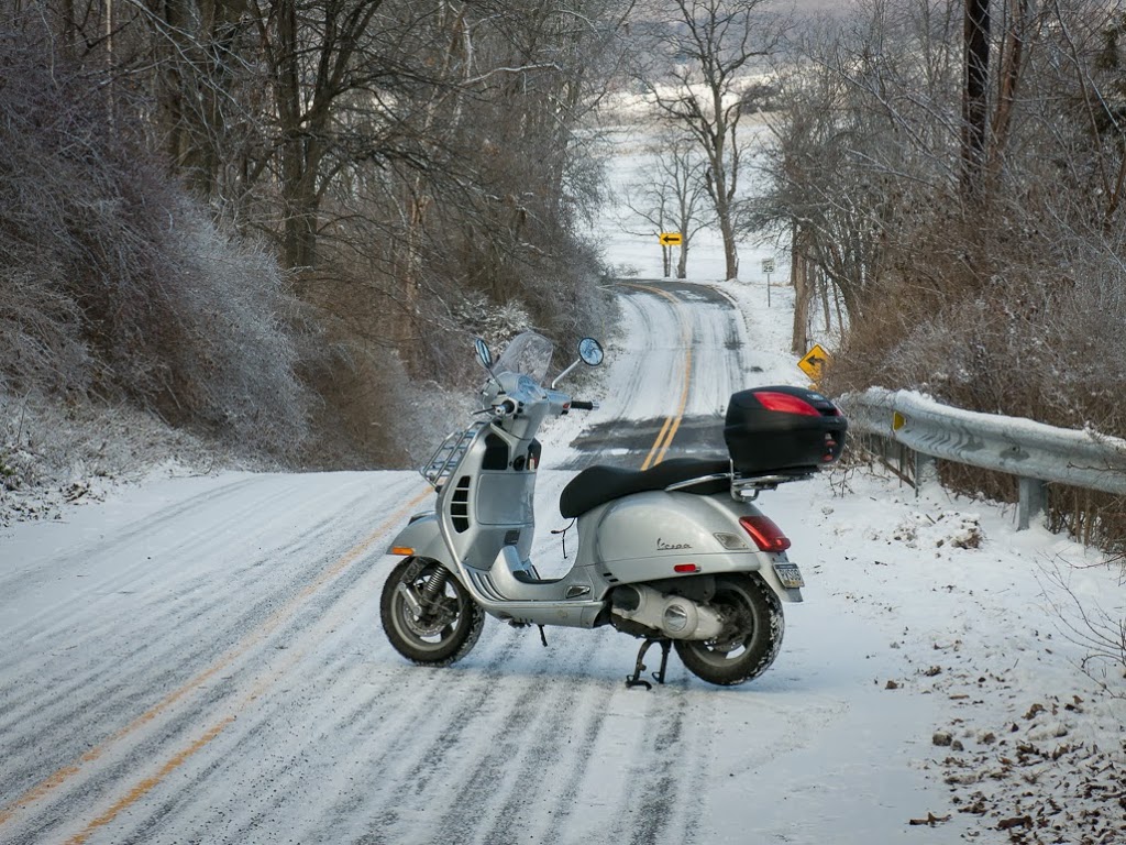 Vespa scooter parked on snow covered road