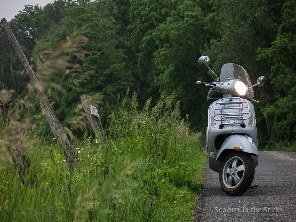 VESPA GTS scooter along a rural road.