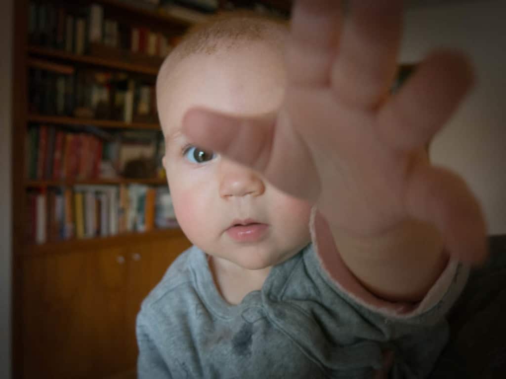 An infant reaching toward the camera