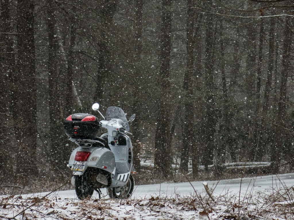 Vespa GTS scooter on snowy forest road