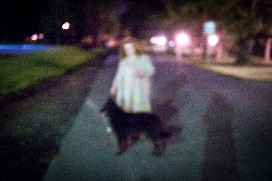 Woman and dog on street at night