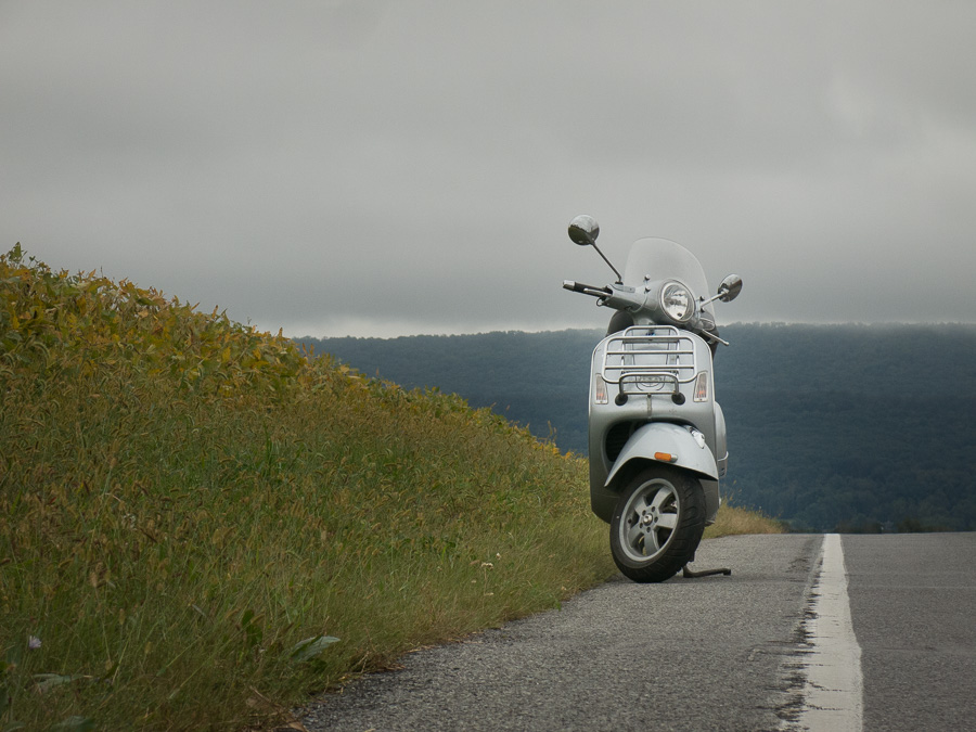 Vespa GTS scooter on gray day along rural road