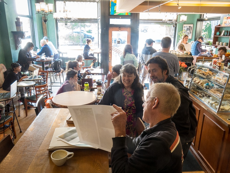 People looking at photographs in Saint's Cafe