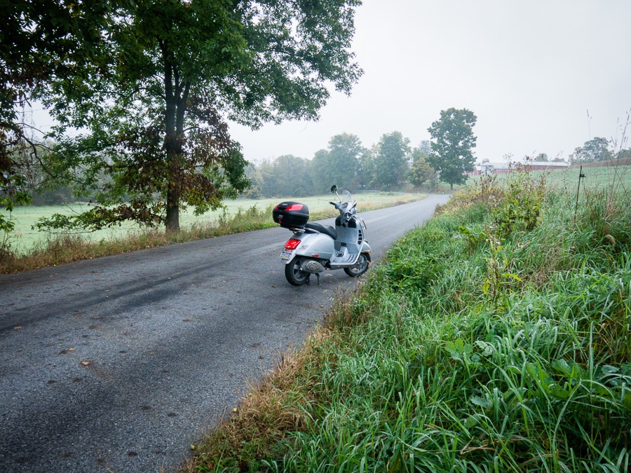 Vespa GTS scooter along rural road on a foggy day