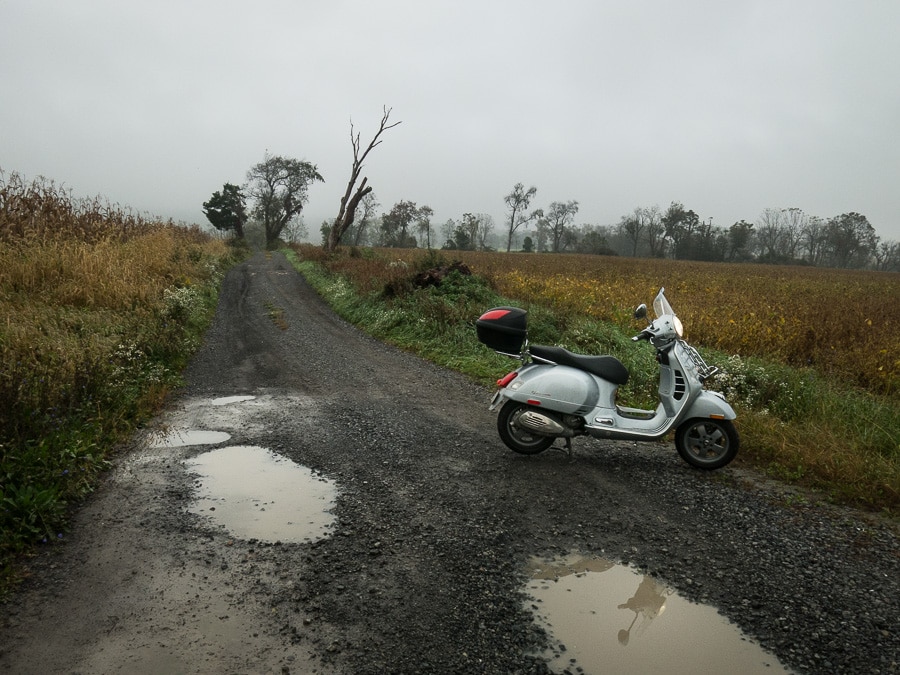 Vespa GTS scooter on a wet gravel road