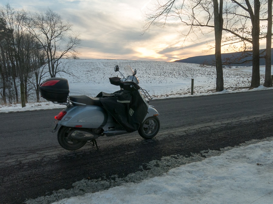 Vespa GTS scooter on rural road in winter.