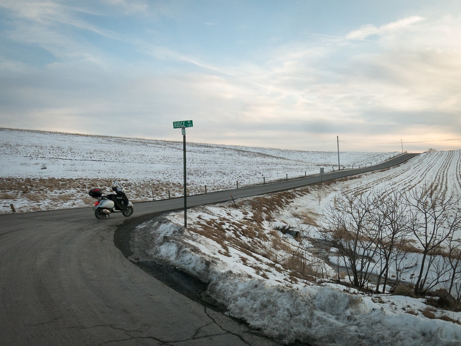 Vespa GTS scooter on a rural road in winter.