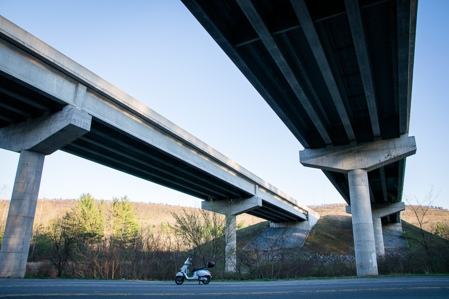 Vespa GTS scooter parked beneath a bridge on Interstate 99.