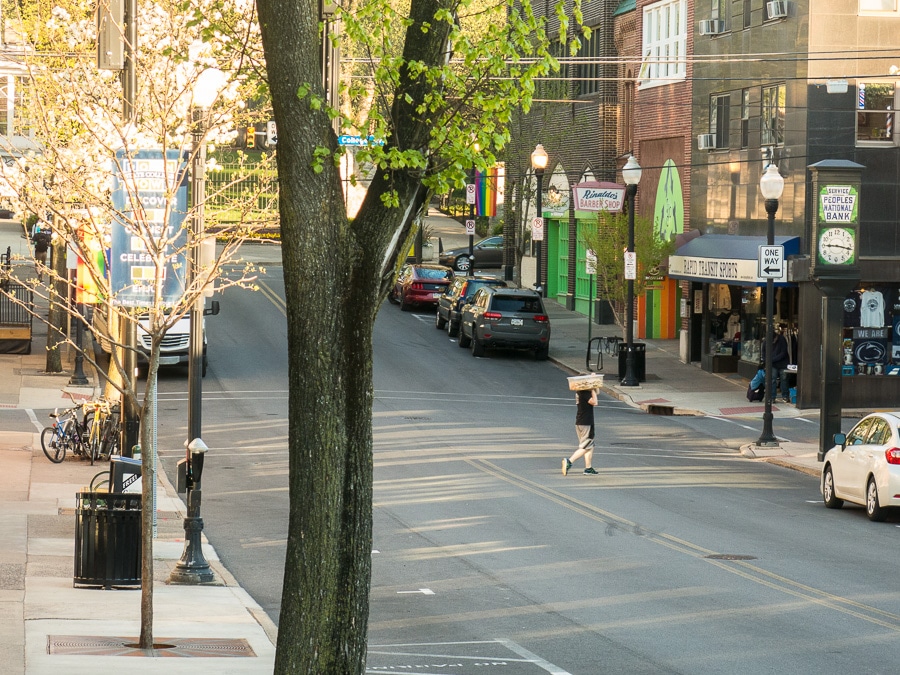 Man walking across a street in early morning