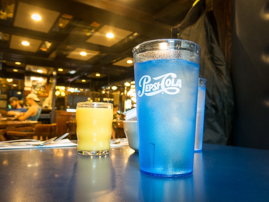 Glasses of orange juice and ice water on a table in restaurant