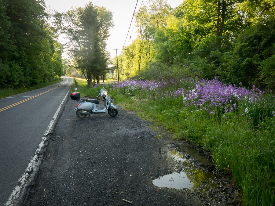 Vespa GTS scooter along a rural road.