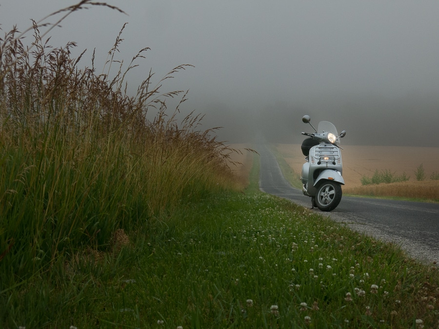 Vespa GTS scooter on a foggy rural road