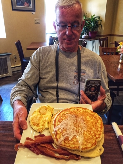 Man with plate of pancakes.