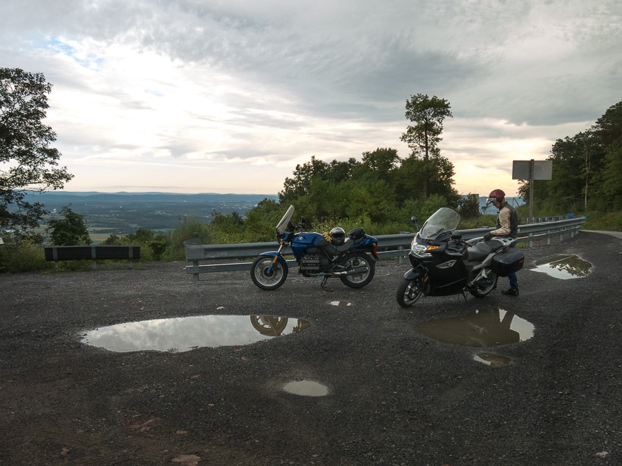 Two motorcycles on a gloomy morning parked at a scenic vista