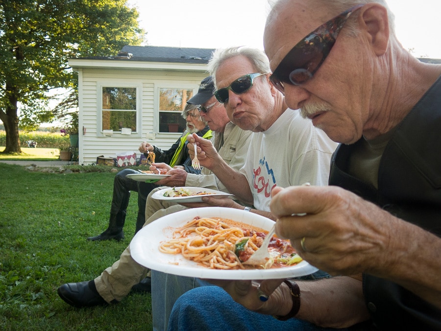 Guys eating spaghetti.