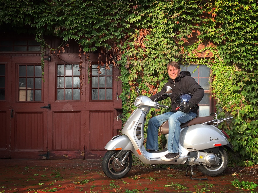 Man sitting on a Vespa scooter