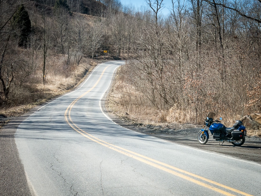 BMW K75 motorcycle along a rural road.