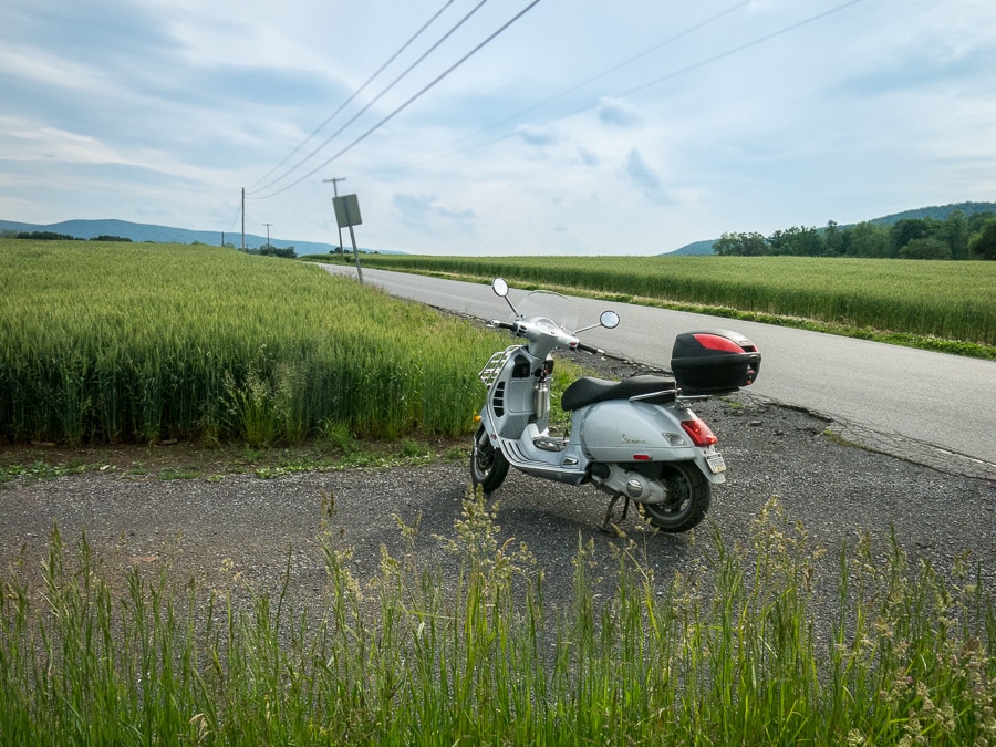 Vespa GTS scooter on a farm lane.