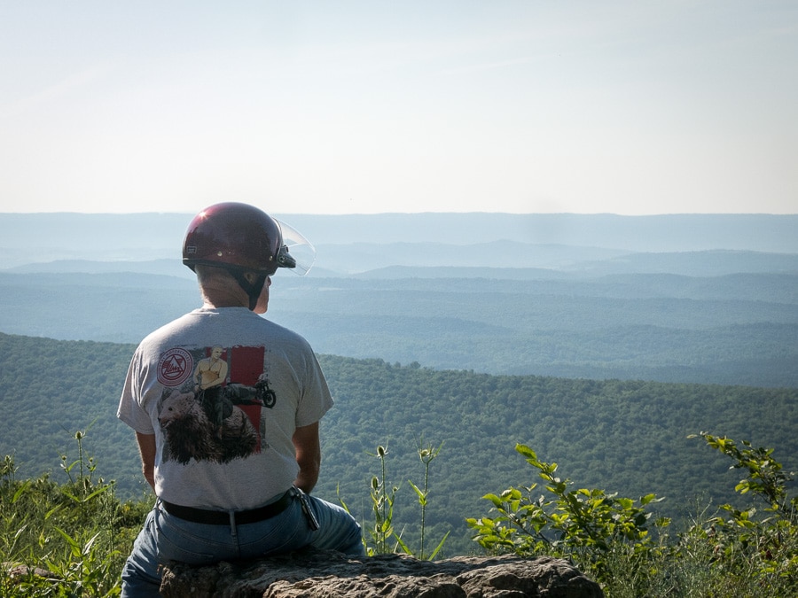 Man sitting at a scenic overlook.
