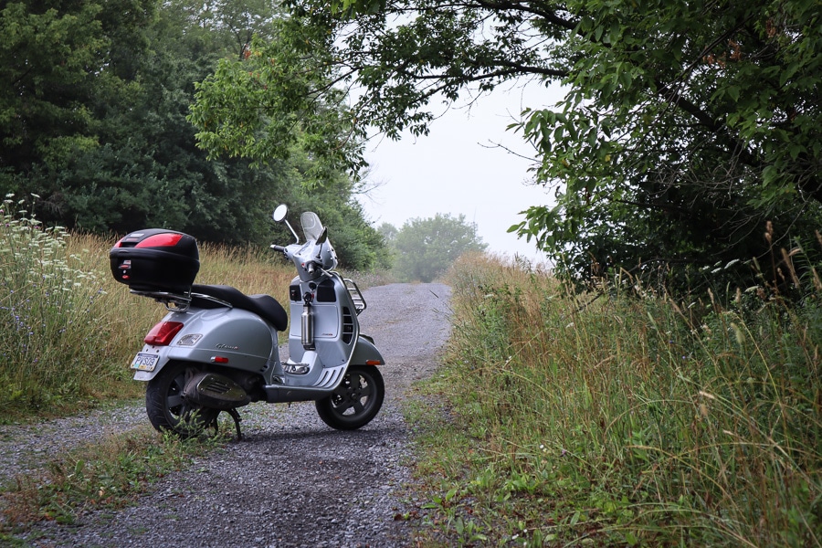 Vespa GTS scooter on gravel road.