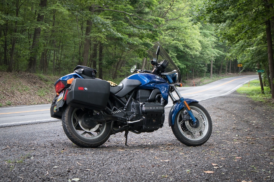BMW K75C motorcycle along rural road.