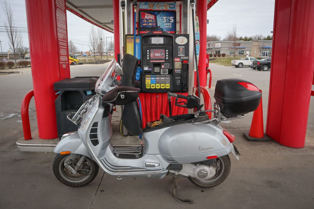 Vespa GTS scooter at a gas station