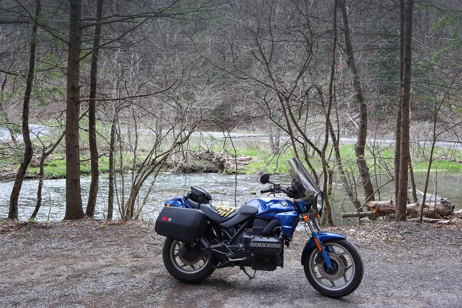 BMW K75 motorcycle along a creek.