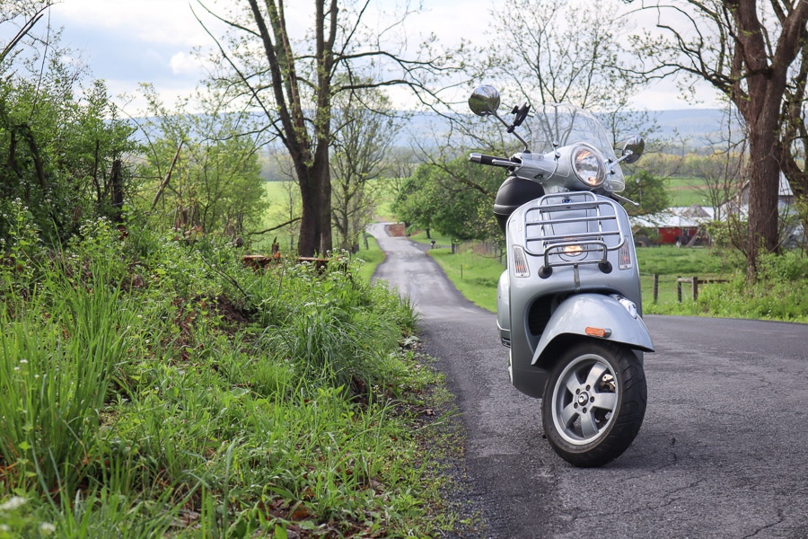 Vespa GTS scooter on rural road.