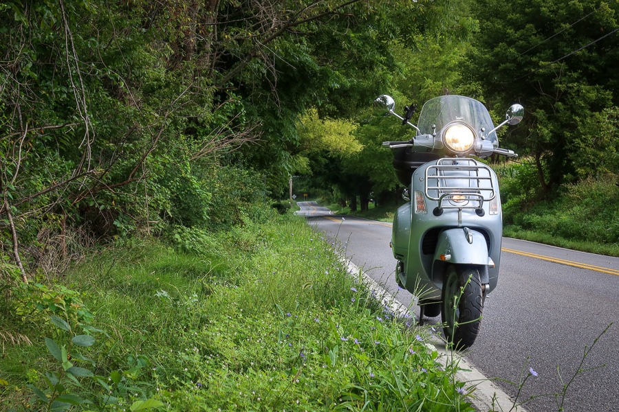 Vespa GTS scooter on a rural road.