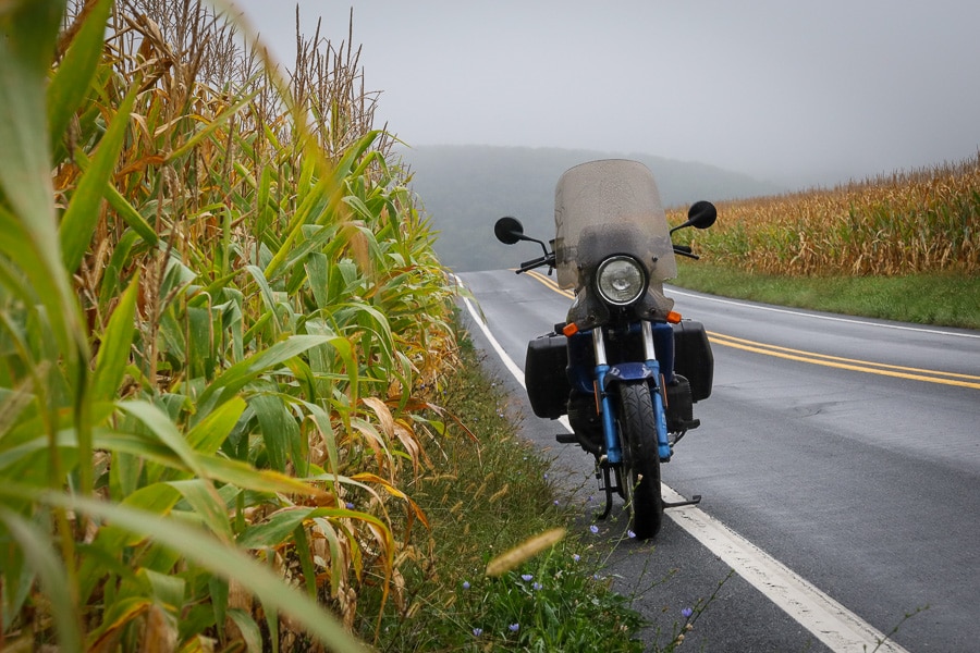 BMW K75C motorcycle on a rural road on a murky morning.