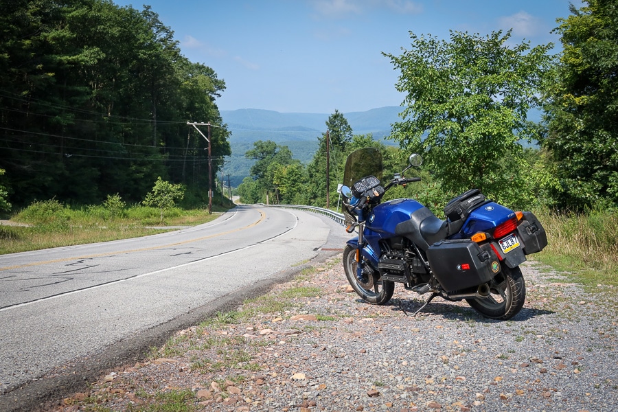 BMW K75C motorcycle along a rural road.
