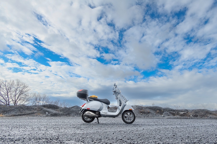 Vespa GTS scooter under a blue sky.