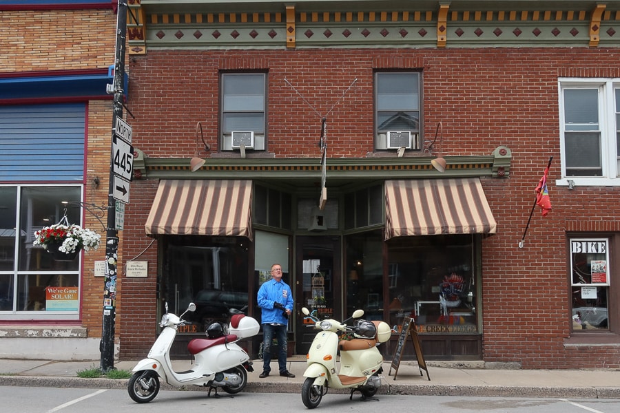 Vespa scooters parked in front of a cafe.