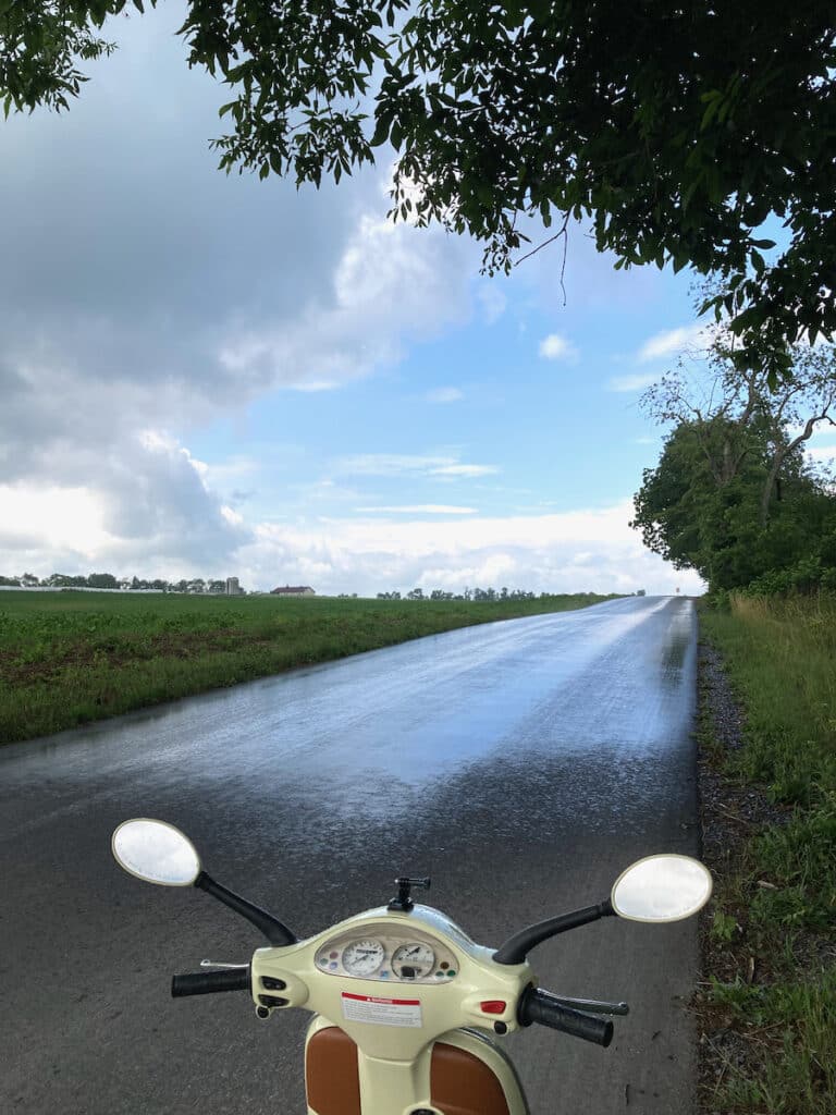 Vespa scooter on a rainy road.