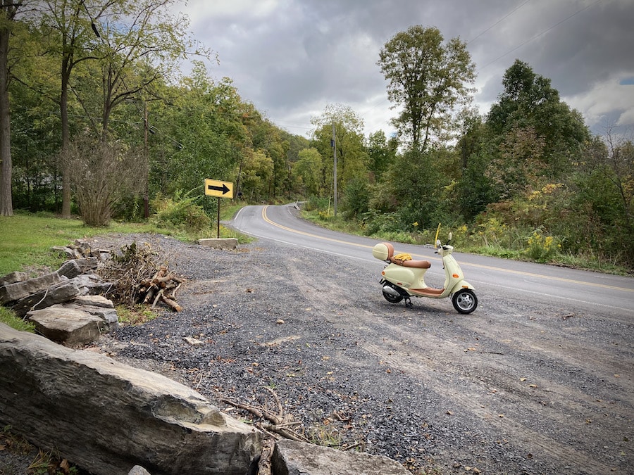 Vespa ET4 scooter along a rural road.