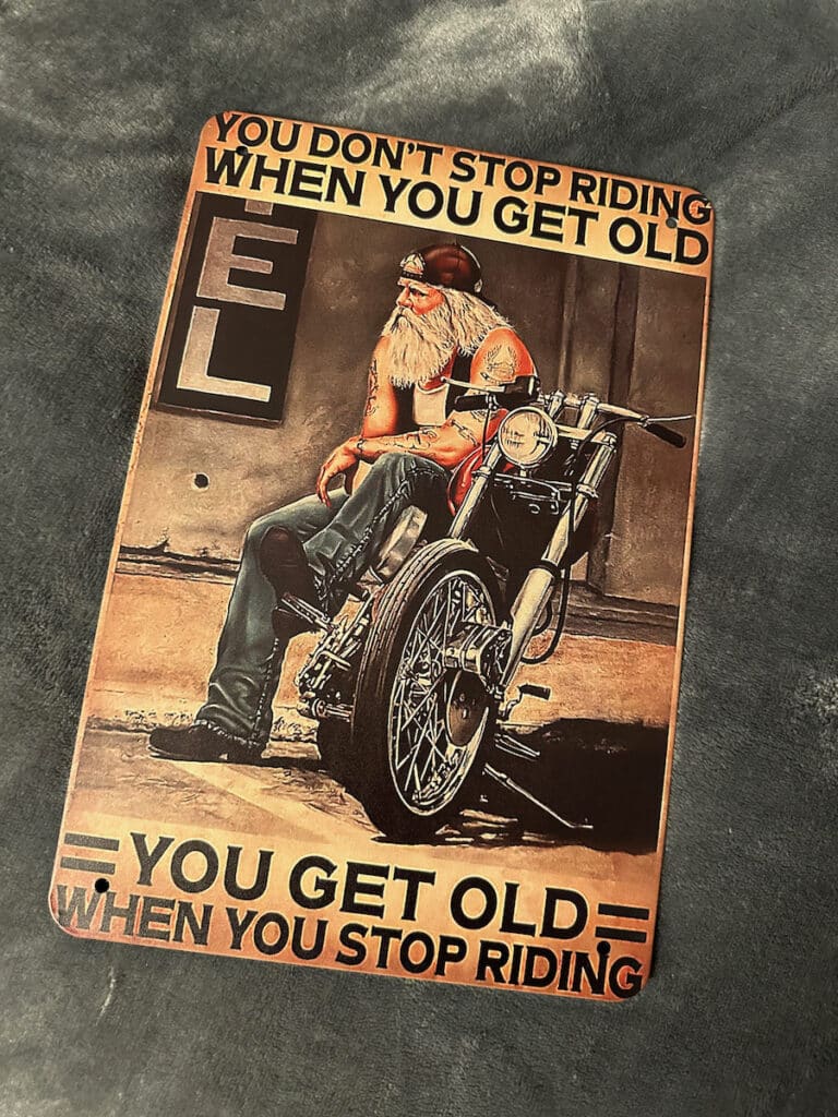 A metal sign about aging and riding.