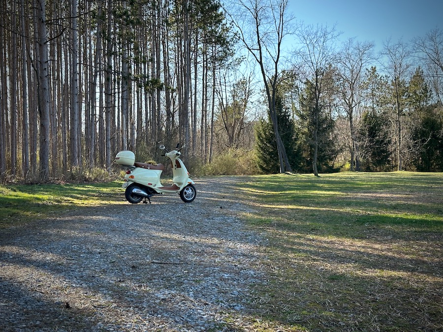 Vespa ET4 scooter parked on a gravel road.