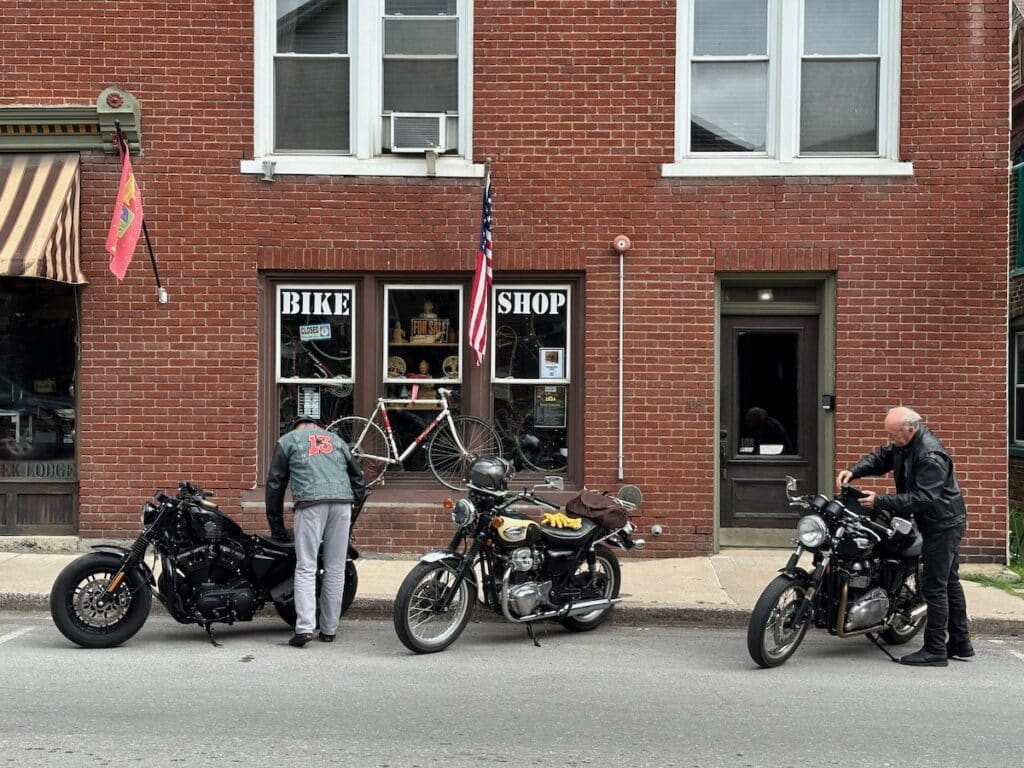 Three motorcycles parked outside the Meandering Mallard cafe.