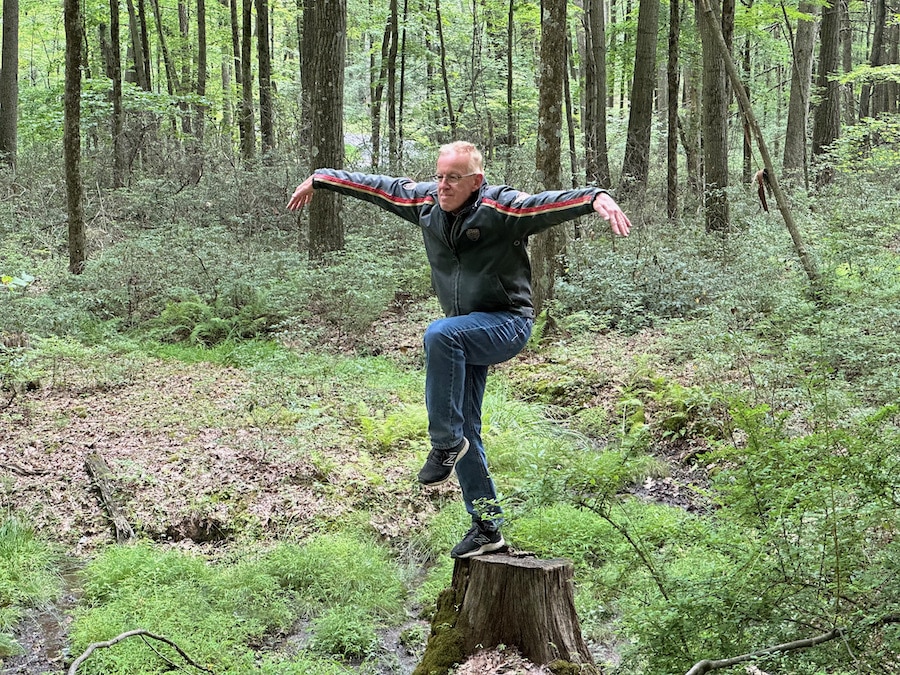 Paul Ruby performs the Crane pose on an old stump