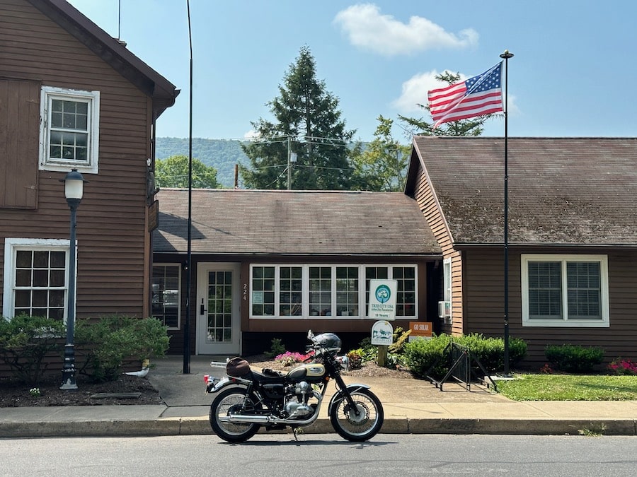 Kawasaki W650 motorcycle parked in front of a municipal building.