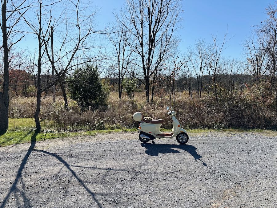 Vespa ET4 scooter parked in a gravel lot.