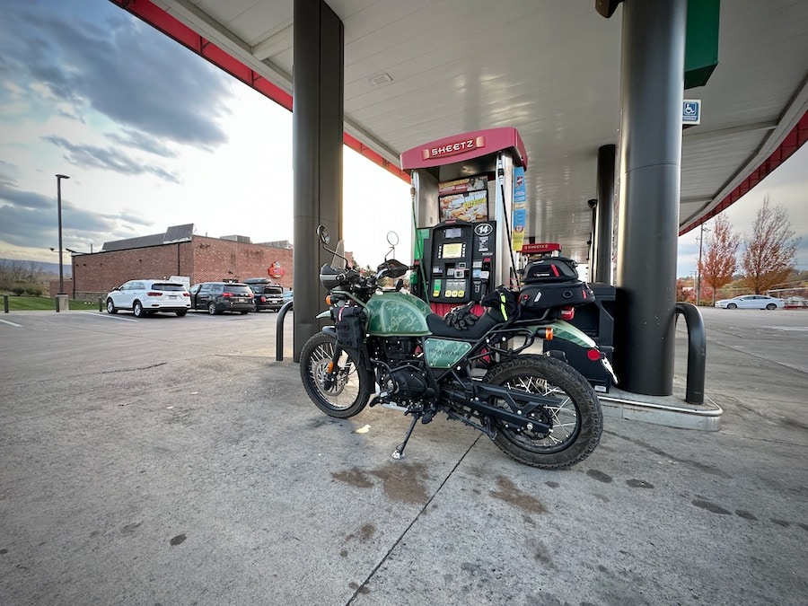 Royal Enfield Himalayan motorcycle at a gas station.