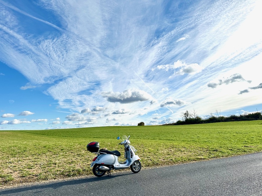 Vespa GTS scooter along a rural road.