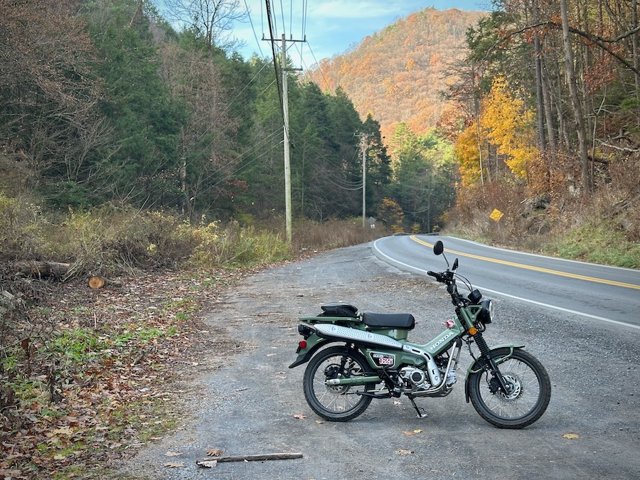 A Honda Trail 125 motorcycle parked along a rural road.