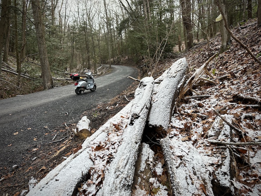 2006 Vespa GTS 250 on a gravel forest road with snow.