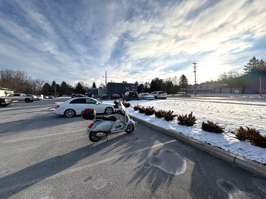 Vespa GTS scooter in a parking lot on a winter morning.