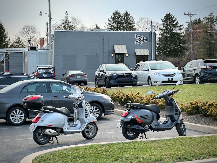 Vespa scooters parked at a restaurant.